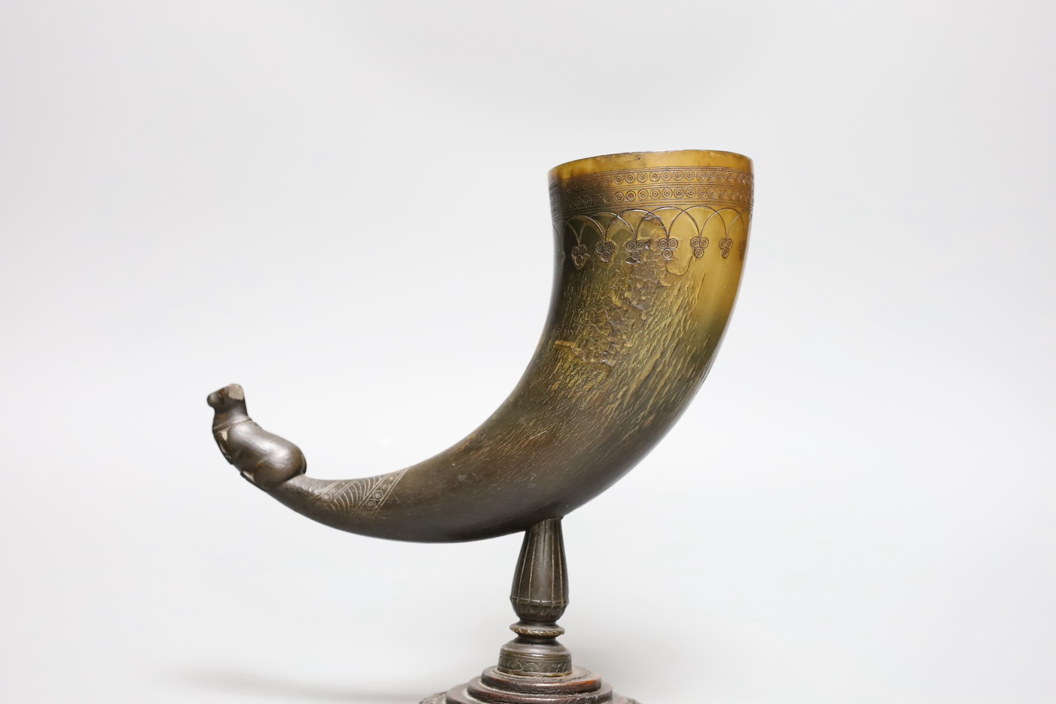 A Persian horn rhyton, 19th century or earlier, with horn stem and stepped wood base, 21cms high, 20.5cm long